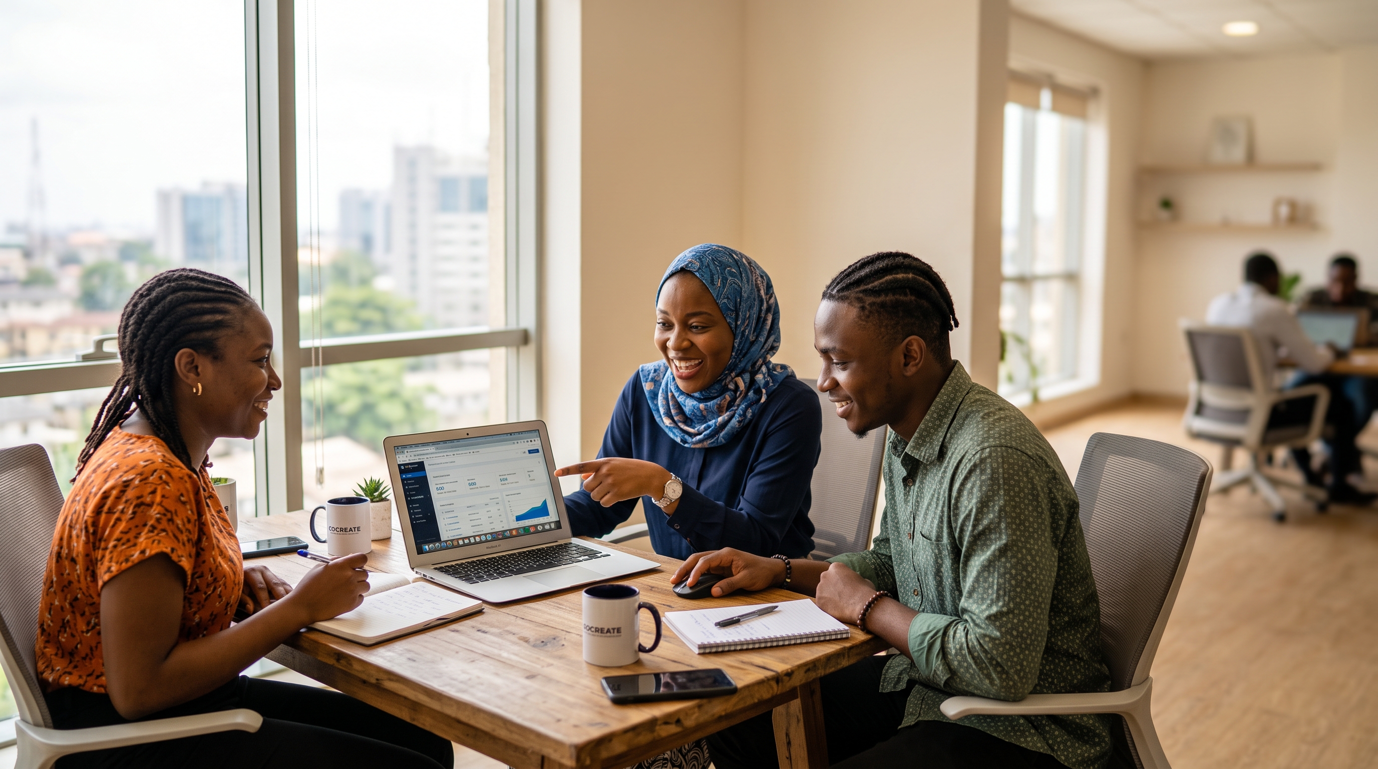 Three colleagues working together around a laptop in an office